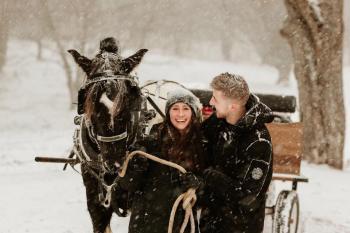 couple with horse drawn carriage in snow